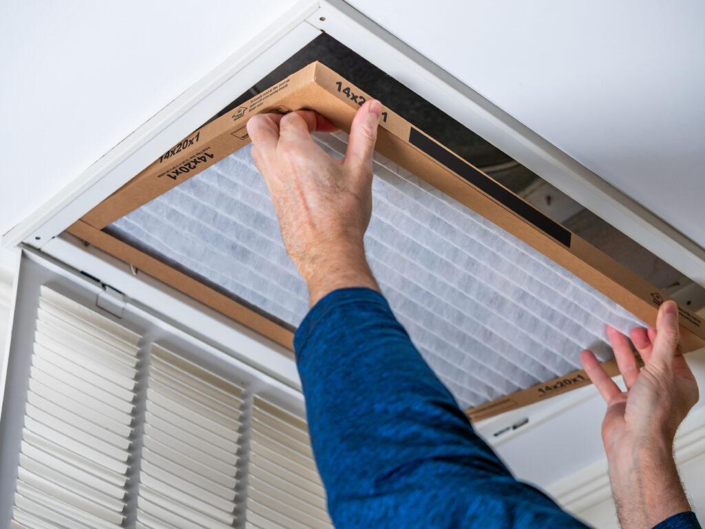 HVAC technician replacing a home air filter in Galt