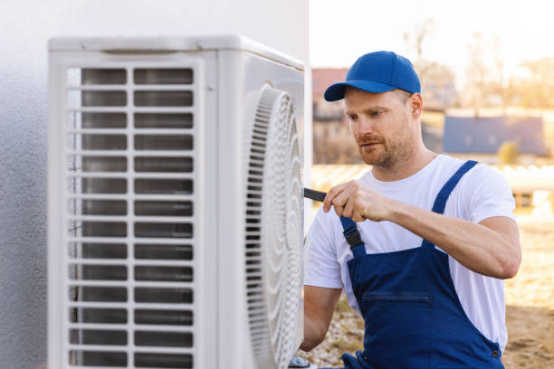 HVAC technician servicing an outdoor air conditioner in Galt