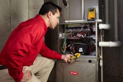 Heating technician diagnosing a furnace repair in Galt
