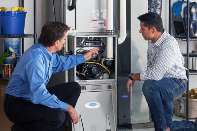 Technician evaluating a furnace for repair or replacement in Galt