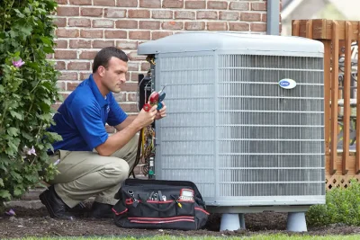 HVAC technician inspecting an outdoor AC unit in Galt